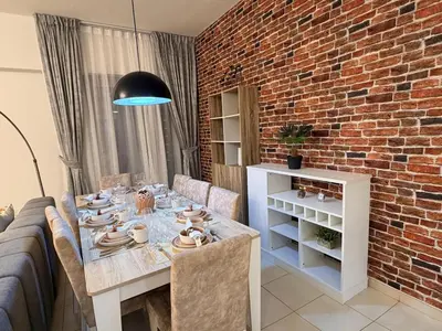 a dining room with a table and a brick wall at Capital Stay - 2 Bed Apt in Business Bay in Dubai