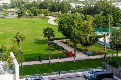 a person riding a bike in a park with palm trees at Warm & Stylish Studio with Balcony in Dubai
