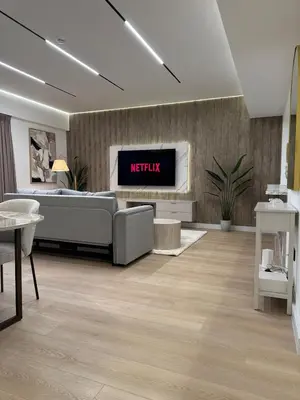 a living room with a couch and a tv on a wall at Sky-High Luxury 1BR Best Views of Dubai Marina Emaar 39th Floor in Dubai