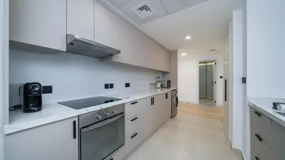 a white kitchen with white cabinets and appliances at Sky-High Luxury 1BR Best Views of Dubai Marina Emaar 39th Floor in Dubai