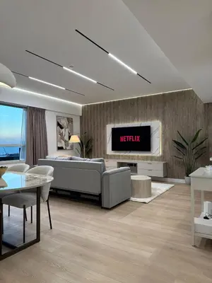 a living room with a couch and a tv on a wall at Sky-High Luxury 1BR Best Views of Dubai Marina Emaar 39th Floor in Dubai