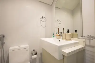 a white bathroom with a sink and a mirror at 3BR Townhouse Rooftop Terrace Just Cavalli in Dubai