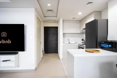 a kitchen with a tv on a white wall at 3BR Townhouse Rooftop Terrace Just Cavalli in Dubai