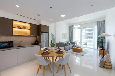 a kitchen and living room with a table and chairs at Grand Bleu 1, Emaar Beachfront - Mint Stay in Dubai