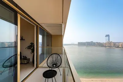 a balcony with two chairs and a view of the water at Grand Bleu, Emaar Beachfront - The Mint Stay in Dubai