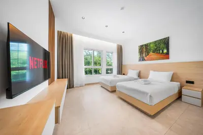 a hotel room with two beds and a flat screen tv at Luxury Spacious 5 bed Villa Pool and Garden in Dubai