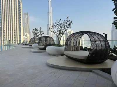a row of curved benches with trees and buildings at Stunning Burj Khalifa View 3BR Imperial Avenue in Dubai