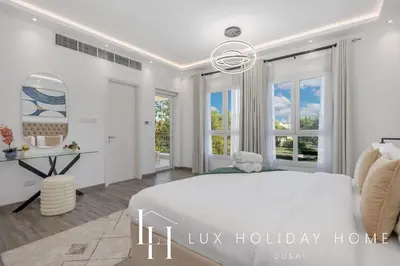 a white bedroom with a bed and a desk at LUX The Serene Springs Villa 2 in Dubai