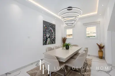 a dining room with a white table and chairs at LUX The Serene Springs Villa 2 in Dubai