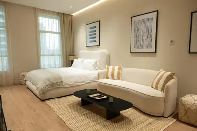 a bedroom with a bed and a couch at Stylish cozy studio in the heart of Business Bay in Sabkhah