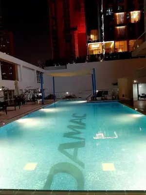 a large blue swimming pool with a chinese symbol on it at Stylish cozy studio in the heart of Business Bay in Sabkhah