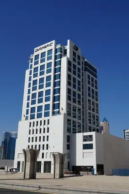 a tall white building with a sign on it at Stylish cozy studio in the heart of Business Bay in Sabkhah