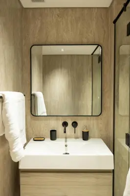 a bathroom with a white sink and a mirror at Stylish cozy studio in the heart of Business Bay in Sabkhah