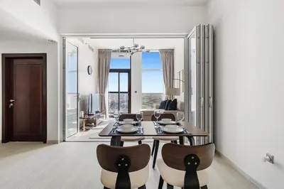 a dining room with a table and some chairs at Cozy 1BR Near Metro in Starz Tower 2 in Dubai