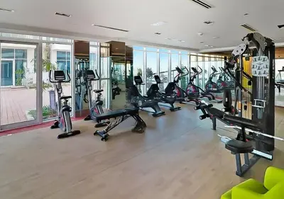 a gym with a bunch of treadmills and exercise bikes at Cozy 1BR Near Metro in Starz Tower 2 in Dubai