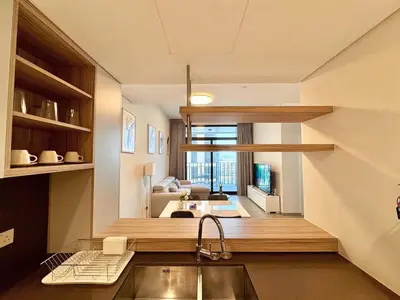 a kitchen with a sink and a view of a living room at Cozy & Stylish 1BR in Wilton Terraces in Dubai