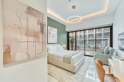a bedroom with a bed and a couch and a table at Fresh & Modern Studio in Meydan - Azizi Riviera 67 in Dubai