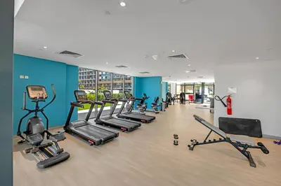 a gym with a row of treadmills and machines at Stylish 1BR in Great Community in Dubai