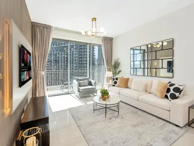 a living room with a white couch and a large window at Kensington - 1BR Fountain-view Flat Downtown in Dubai
