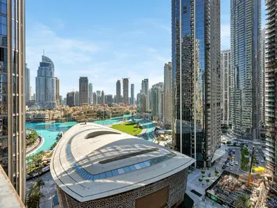 a large building in a city with tall buildings at Kensington - 1BR Fountain-view Flat Downtown in Dubai