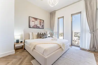 a white bedroom with a bed and a large window at Just Steps from the Community Center with Top-Tier Amenities, Minutes Walk to the Park, Hayat Boulevard 2A, Town Square by Deluxe Holiday Homes in Dubai