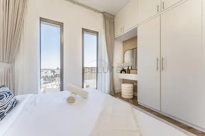 a white bedroom with a large bed and large windows at Just Steps from the Community Center with Top-Tier Amenities, Minutes Walk to the Park, Hayat Boulevard 2A, Town Square by Deluxe Holiday Homes in Dubai