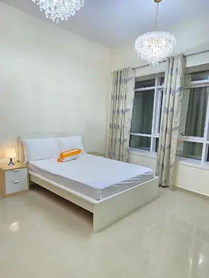 a white bedroom with a bed and two windows at Large 2 BHK Apartment Next to DMCC Metro Station in Dubai
