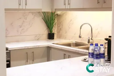 a kitchen with a sink and bottles of water on a counter at Cloud 9 - Steps to the Beach Elegant 2BR in JBR in Dubai