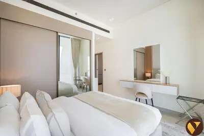 a bedroom with a large white bed and a desk at Vogue JVC Binghatti Phantom near Circle Mall, One Bedroom Apartment with Large Balcony and City View, Access to all Amenities in Dubai