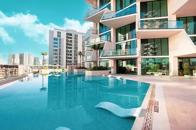 a large swimming pool in front of a building at Vogue JVC Binghatti Phantom near Circle Mall, One Bedroom Apartment with Large Balcony and City View, Access to all Amenities in Dubai
