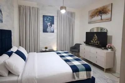 a bedroom with a bed and a tv in it at 1BR with Burj Khalifa Modern Comfort in Dubai