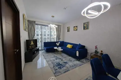 a living room with a blue couch and a tv at 1BR with Burj Khalifa Modern Comfort in Dubai