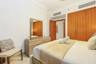 a bedroom with a bed and a mirror and a chair at Keylid Stunning3BR and Maid connected to Dubai Mall in Dubai