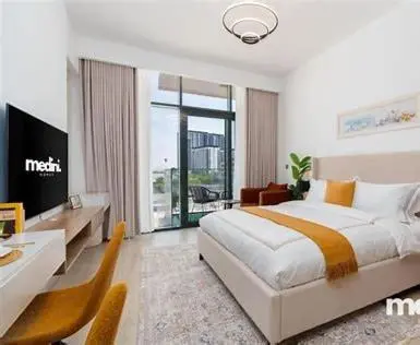 a bedroom with a bed and a desk and a tv at Dubai aziIzi in Dubai