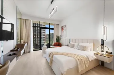 a white bedroom with a large bed and a large window at Dubai aziIzi in Dubai