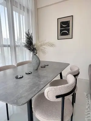 a dining room table with chairs and a vase on it at 1BR Amazing Burj And Dubai View in Dubai
