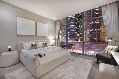 a bedroom with a large bed and a large window at StayMada - Peninsula Exclusive Canal Front Retreat in Dubai