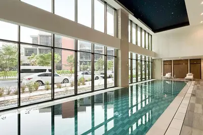 a swimming pool in a building with large windows at StayMada - Peninsula Exclusive Canal Front Retreat in Dubai