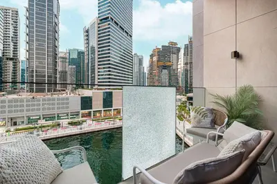 a balcony with chairs and a view of a city at StayMada - Peninsula Exclusive Canal Front Retreat in Dubai