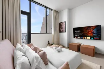 a living room with a white couch and a tv at New 1BR with Private Pool Near Circle Mall in Dubai