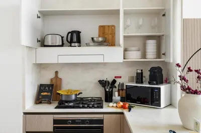 a kitchen with white cabinets and a stove top oven at New 1BR with Private Pool Near Circle Mall in Dubai
