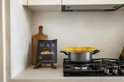 a pot of pasta on a stove with a sign at Stylish 1BR with Private Pool Near Circle Mall in Dubai