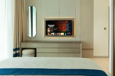 a bedroom with a bed and a tv on a wall at Royale Family Apartment 281 with Plunge Pool in Dubai