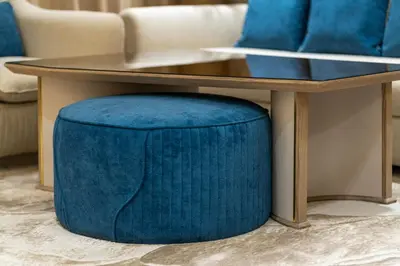 a coffee table with a blue ottoman under a table at Royale Family Apartment 281 with Plunge Pool in Dubai