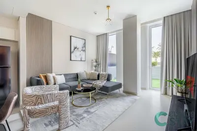 a living room with a couch and a table at Cloud 9 - Townhouse style 2 BR Apt with BBQ Patio in Dubai