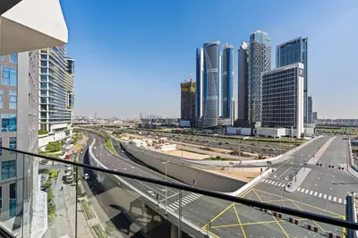 a view of a city with tall buildings and a highway at Cozy City-View Studio w Balcony & Queen Bed in Dubai