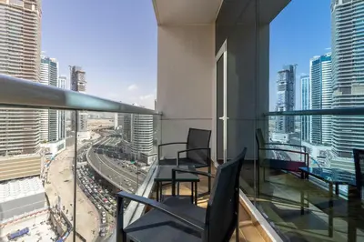 a balcony with chairs and a view of a city at Maison Privee - Comfortable Downtown Apartment with City Skyline Vws in Dubai