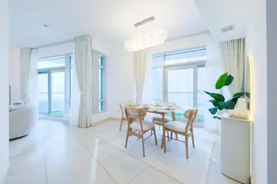 a white dining room with a table and chairs at Premium Burj Khalifa View Downtown Dubai in Dubai