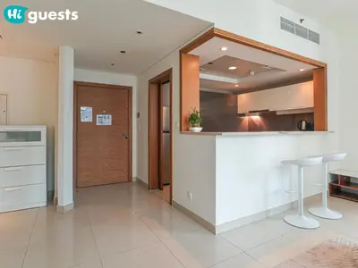 a kitchen with a white counter and a bar with stools at HiGuests - Family Friendly 1BR Near Burj Khalifa in Dubai