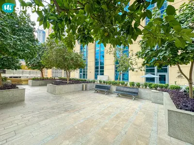 a park with benches and trees in front of a building at HiGuests - Family Friendly 1BR Near Burj Khalifa in Dubai